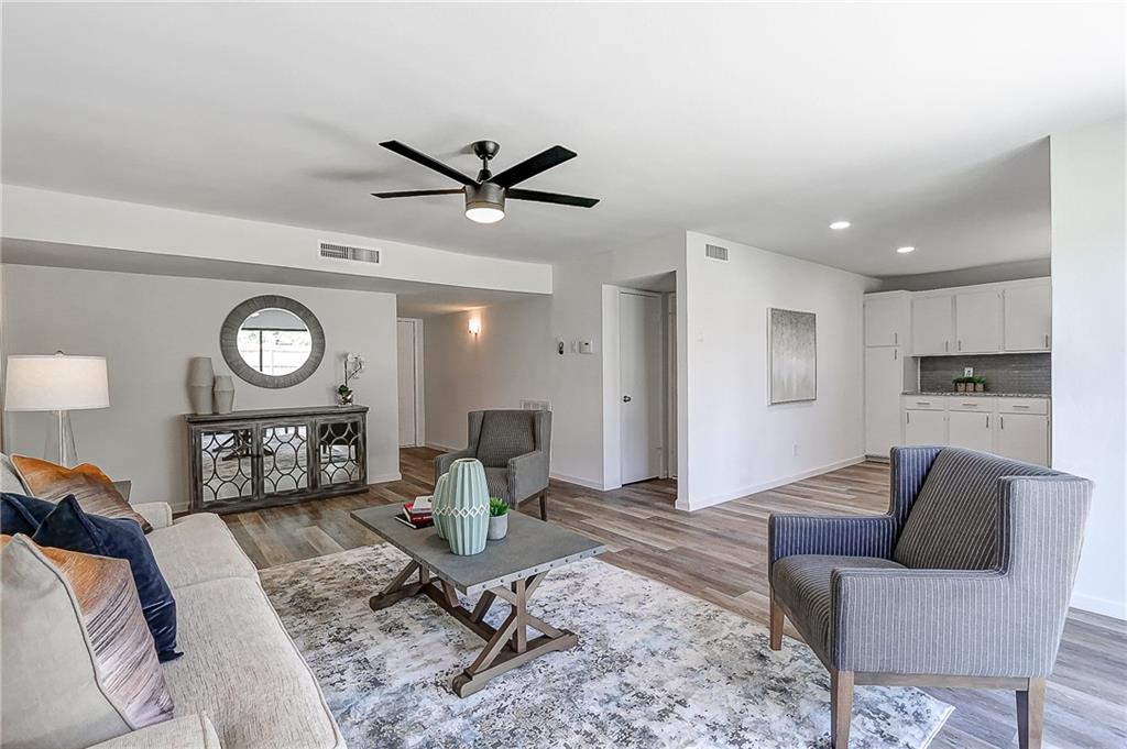 a living room with furniture a clock on wall and a table