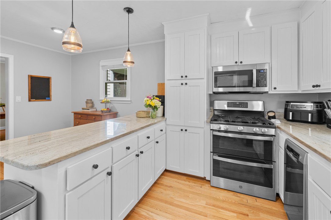 203 Augusta Road Clemson, SC 29631 - Photo 15 of 31 White cabinetry, granite counters, and stainless steel appliances create a functional and appealing kitchen space.