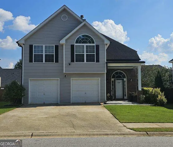 a front view of a house with a garden and garage