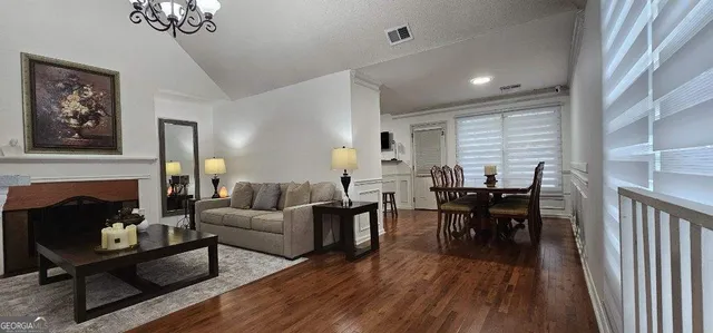 a living room with furniture a fireplace and a chandelier