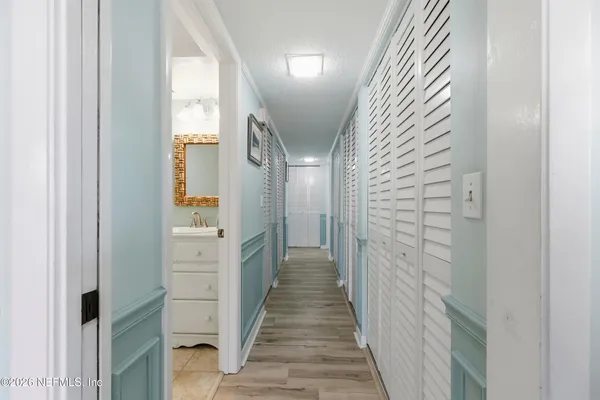 a view of a hallway with wooden floor and staircase
