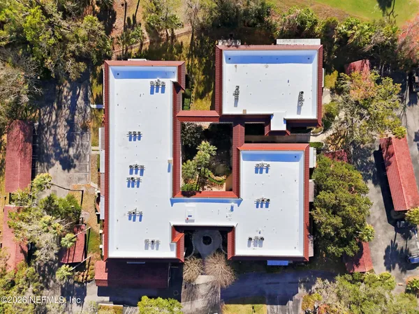 a view of a brick house with a large windows and flower plants