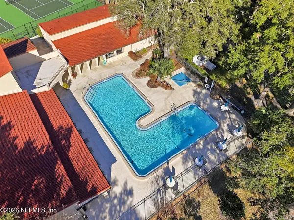a view of a tennis ground with large trees