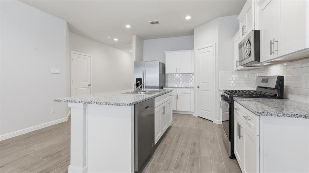 9621 Austin Holw Road Fort Worth, TX 76036 - Photo 2 of 23 a kitchen with stainless steel appliances granite countertop a sink stove and cabinets