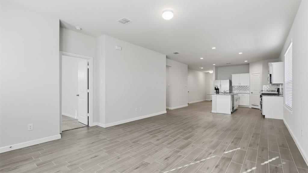 9621 Austin Holw Road Fort Worth, TX 76036 - Photo 6 of 23 a view of an empty room with wooden floor and a window