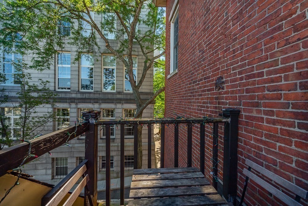 26 Cedar Street Boston, MA 02129 - Photo 19 of 19 a balcony with wooden floor and outdoor seating