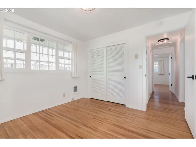 a view of an empty room with wooden floor