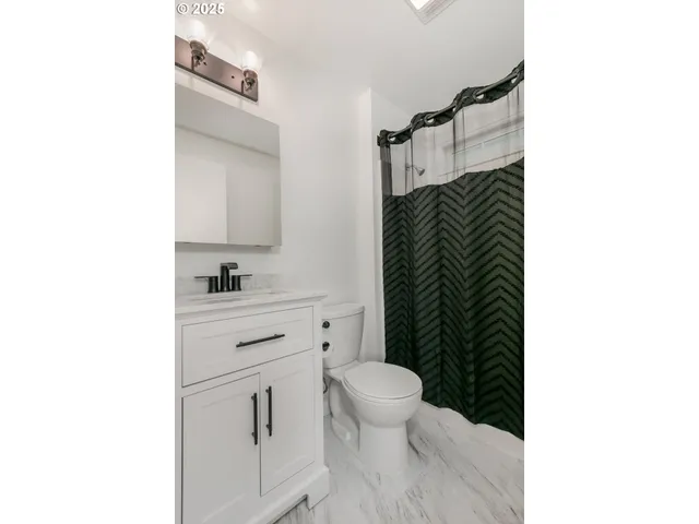 a bathroom with a toilet a sink and shower