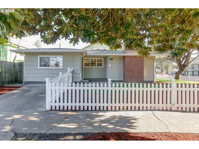 a view of a house with a wooden fence
