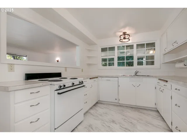a kitchen with granite countertop white cabinets and white appliances