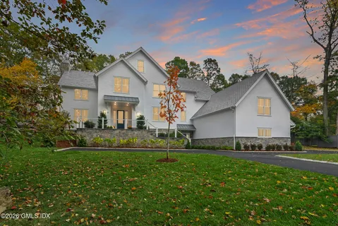 a front view of a house with a yard and trees