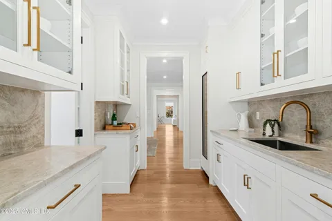 a large kitchen with stainless steel appliances granite countertop a sink and cabinets with wooden floor