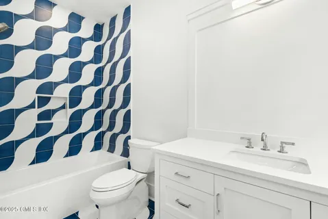 a bathroom with a sink a toilet a mirror and shower curtain