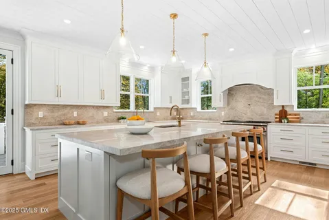 a kitchen with white cabinets and sink