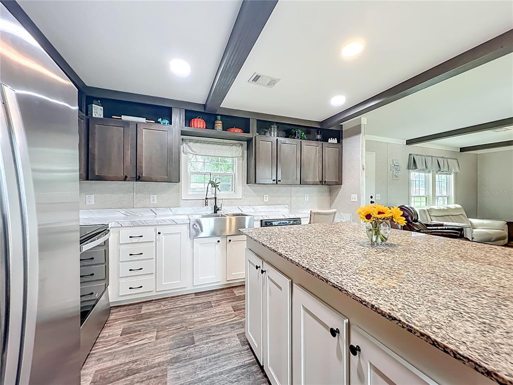 2815 Southwest 89th Place Ocala, FL 34476 - Photo 12 of 36 a kitchen with stainless steel appliances granite countertop a sink stove and cabinets