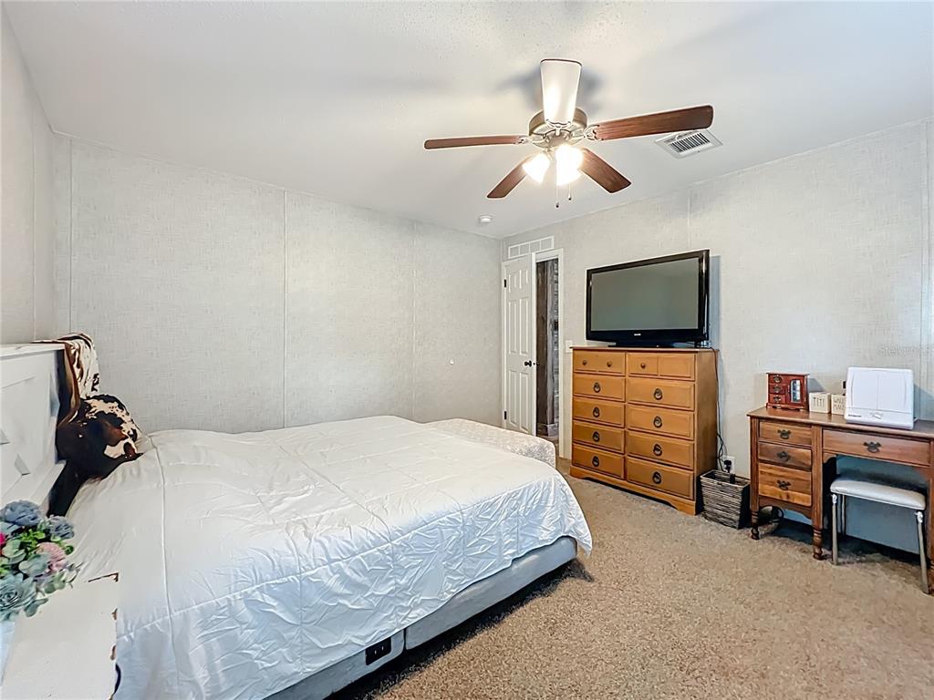 2815 Southwest 89th Place Ocala, FL 34476 - Photo 14 of 36 a bedroom with a bed and a flat screen tv