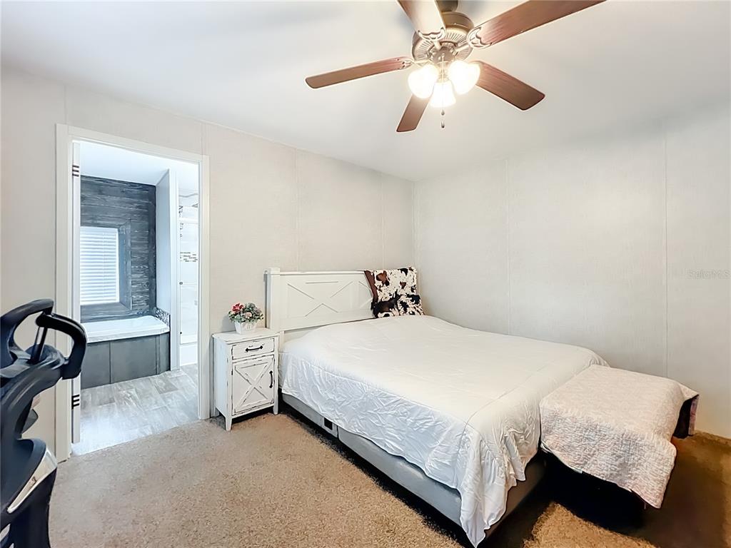 2815 Southwest 89th Place Ocala, FL 34476 - Photo 15 of 36 a bedroom with a bed and a chandelier