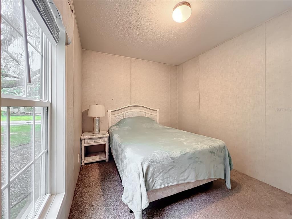 2815 Southwest 89th Place Ocala, FL 34476 - Photo 22 of 36 a bedroom with a bed and a large window