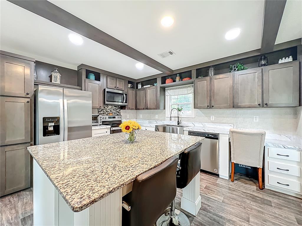 2815 Southwest 89th Place Ocala, FL 34476 - Photo 4 of 36 a kitchen with granite countertop a sink a counter space appliances and cabinets