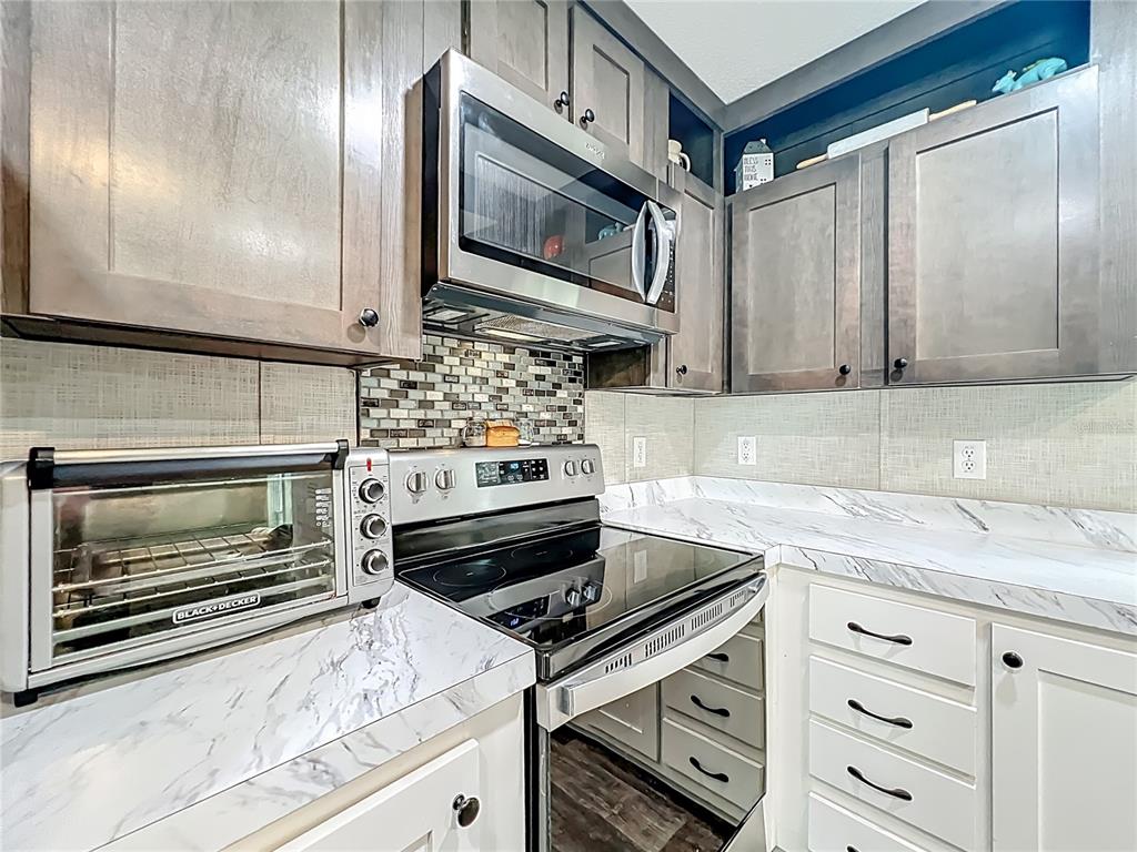 2815 Southwest 89th Place Ocala, FL 34476 - Photo 6 of 36 a kitchen with granite countertop cabinets stainless steel appliances and a counter space