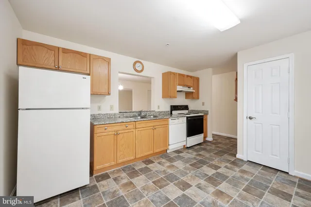 a kitchen with stainless steel appliances granite countertop a refrigerator sink and white cabinets