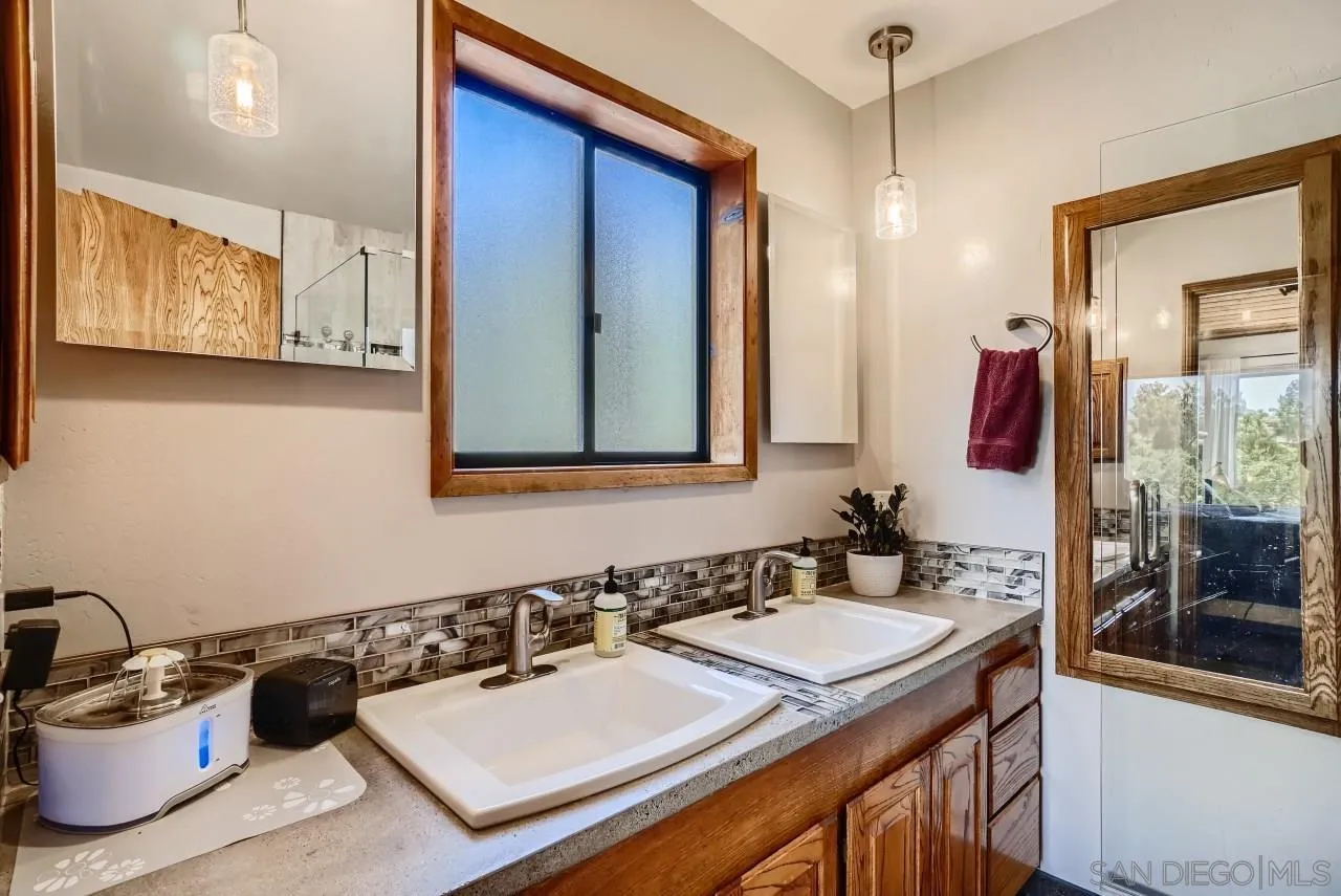 14461 Lyons Valley Road Jamul, CA 91935 - Photo 15 of 27 a bathroom with a sink a vanity and a mirror
