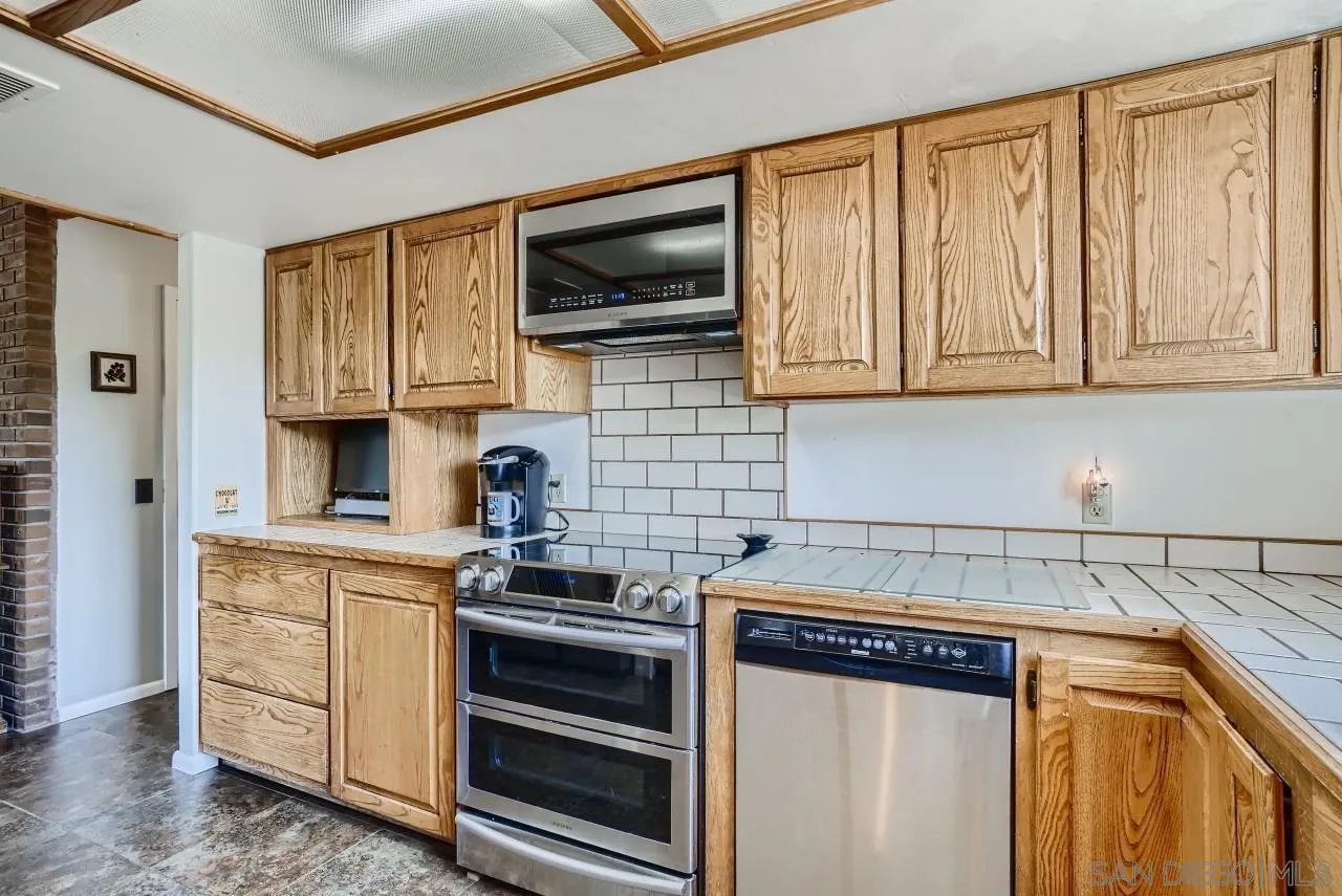 14461 Lyons Valley Road Jamul, CA 91935 - Photo 9 of 27 a kitchen with stainless steel appliances granite countertop a stove and a microwave