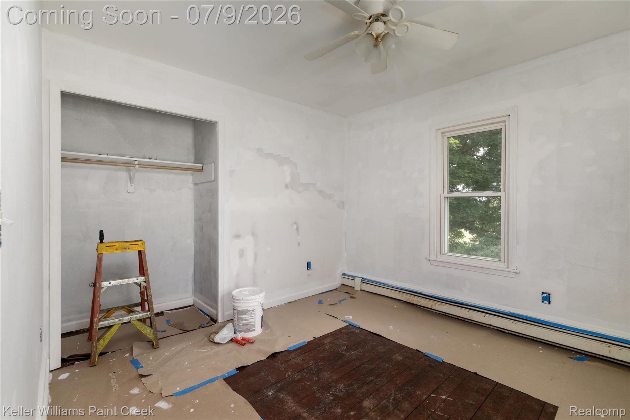 28780 School Section Road Richmond, MI 48062 - Photo 13 of 50 Room featuring a single-hung window, a ceiling fan with light fixture, baseboard heating, an open closet with hanging rod, and exposed wood flooring