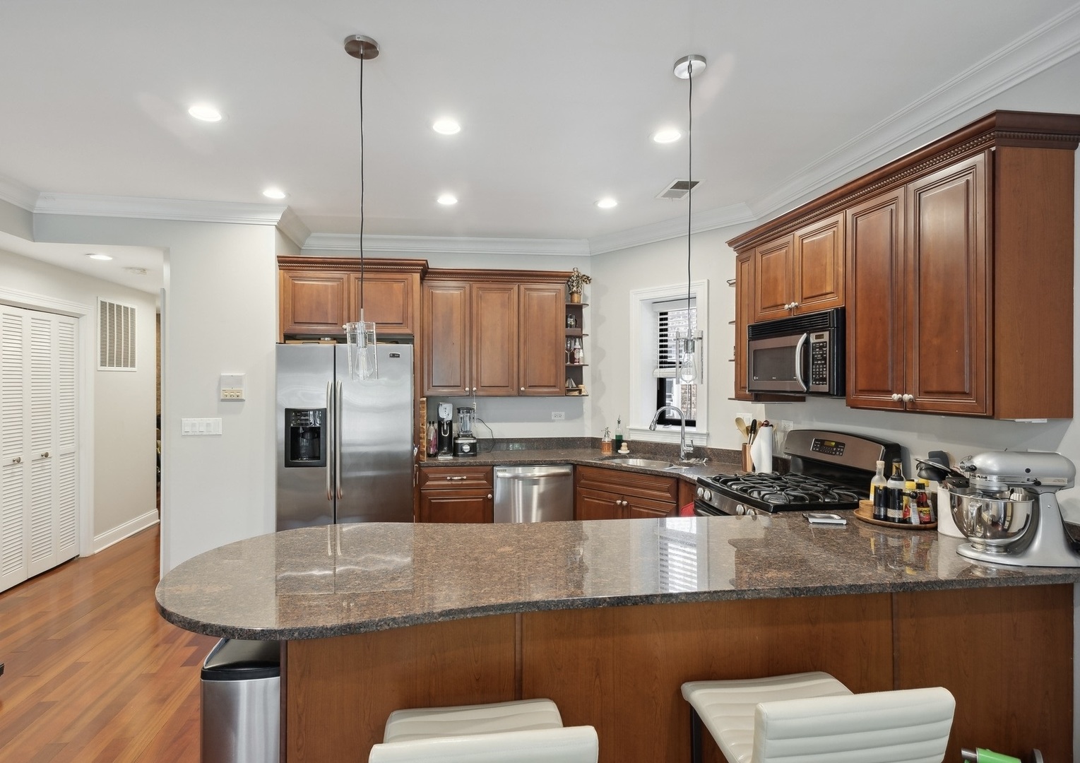 2324 West Argyle Street, Unit 2E Chicago, IL 60625 - Photo 5 of 14 a kitchen with stainless steel appliances granite countertop a sink a refrigerator and couches