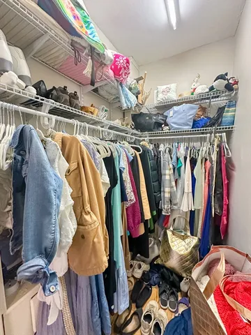 a view of walk in closet with clothes