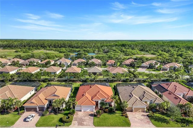an aerial view of residential houses with outdoor space and trees
