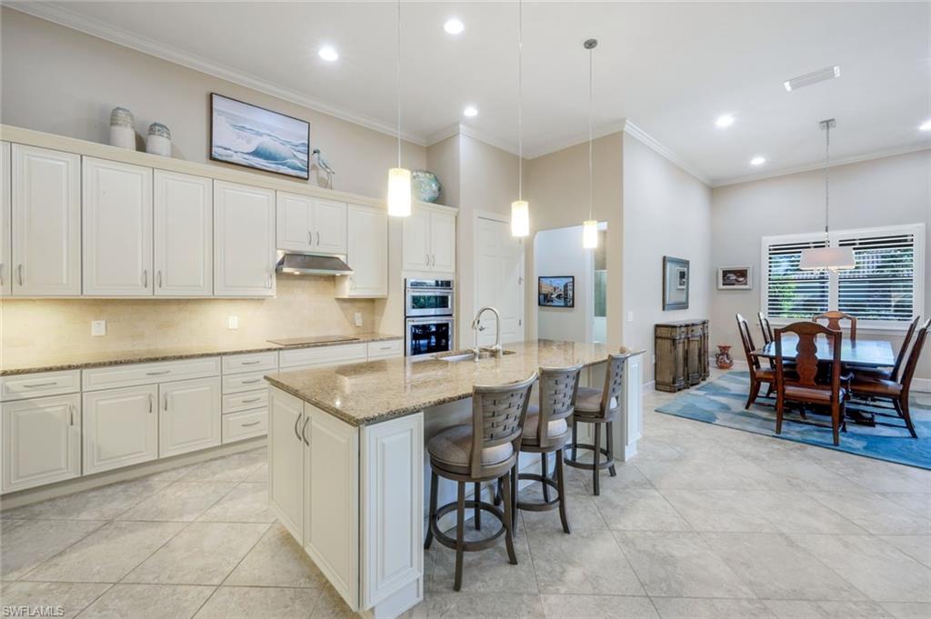 9282 Quarry Drive Naples, FL 34120 - Photo 11 of 50 a kitchen with cabinets table and chairs