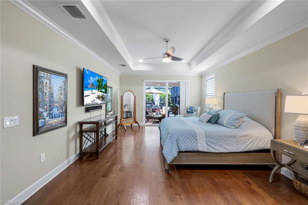 9282 Quarry Drive Naples, FL 34120 - Photo 16 of 50 a bedroom with a bed furniture and wooden floor