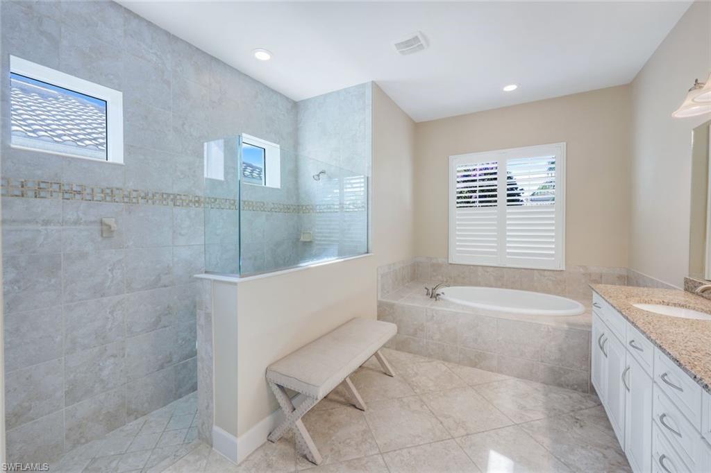9282 Quarry Drive Naples, FL 34120 - Photo 19 of 50 a spacious bathroom with a granite countertop tub sink and mirror
