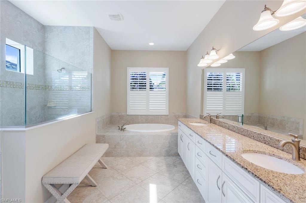 9282 Quarry Drive Naples, FL 34120 - Photo 20 of 50 a spacious bathroom with a granite countertop tub sink and mirror