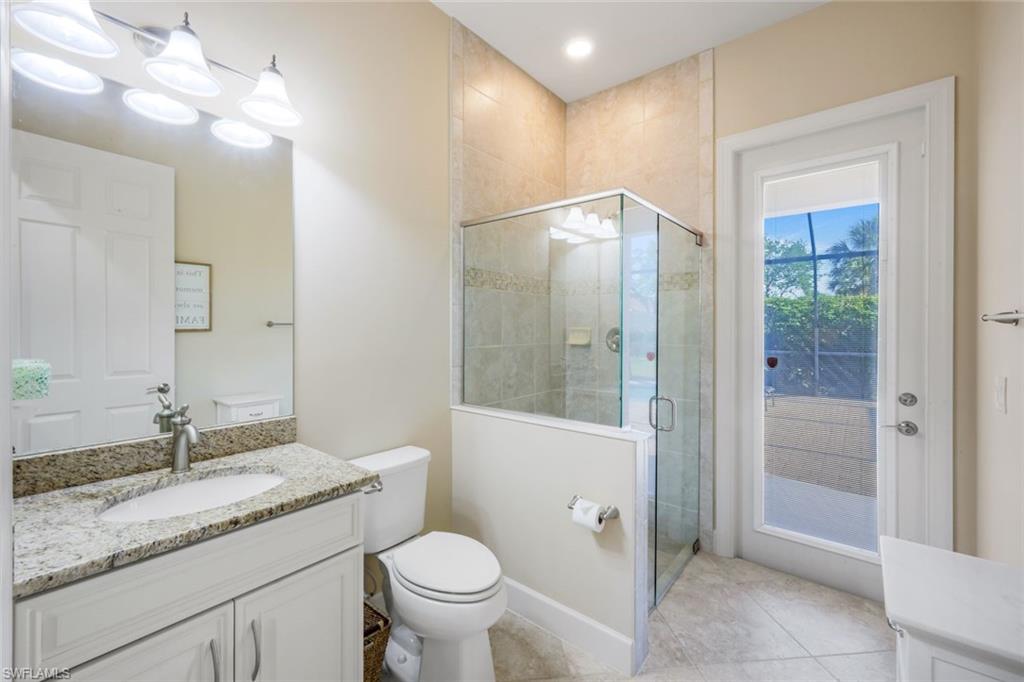 9282 Quarry Drive Naples, FL 34120 - Photo 23 of 50 a bathroom with a granite countertop sink toilet and shower