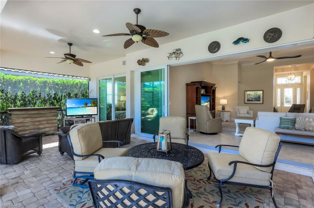 9282 Quarry Drive Naples, FL 34120 - Photo 29 of 50 a living room with furniture a ceiling fan and a large window