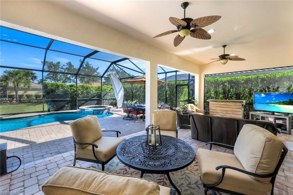 9282 Quarry Drive Naples, FL 34120 - Photo 30 of 50 a living room with furniture a fireplace and a floor to ceiling window