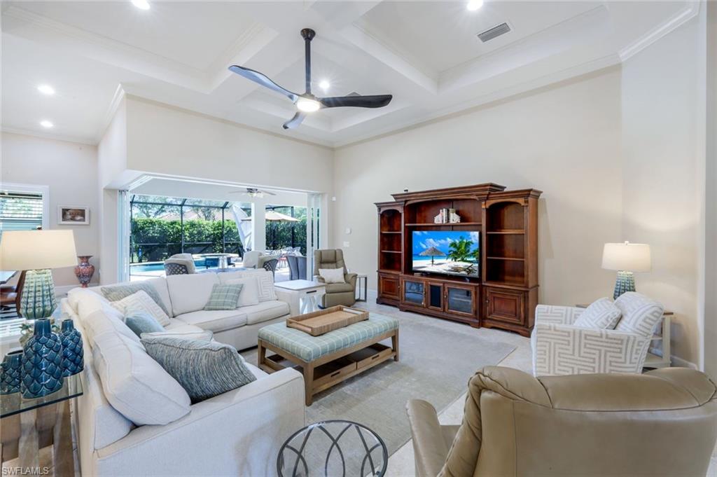 9282 Quarry Drive Naples, FL 34120 - Photo 8 of 50 a living room with furniture a large window and a flat screen tv