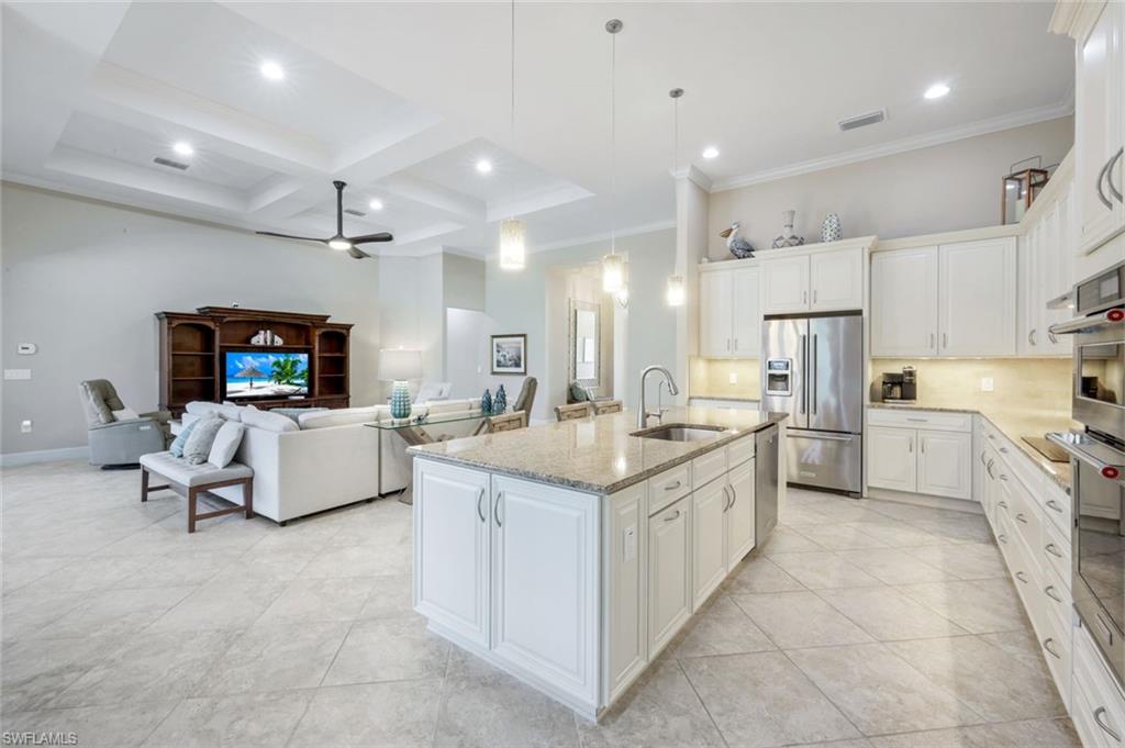 9282 Quarry Drive Naples, FL 34120 - Photo 9 of 50 a large white kitchen with a large counter top and stainless steel appliances