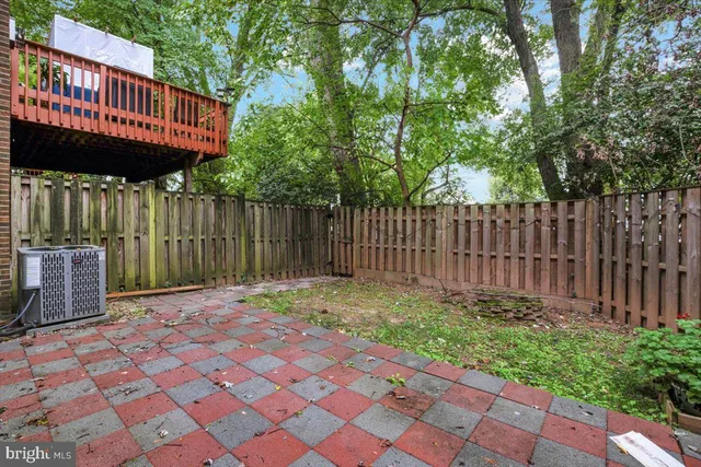 a view of backyard with a patio and wooden fence