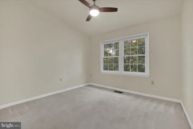 an empty room with a window and a ceiling fan