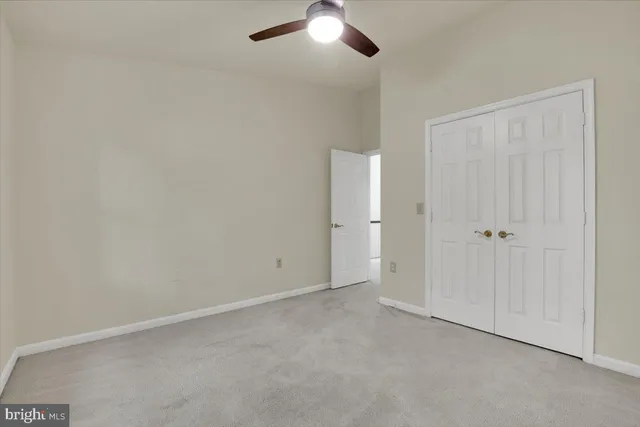 an empty room with chandelier fan