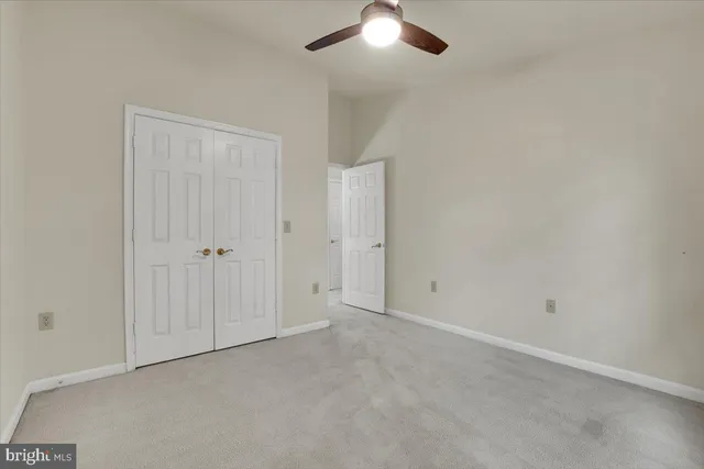 an empty room with chandelier fan