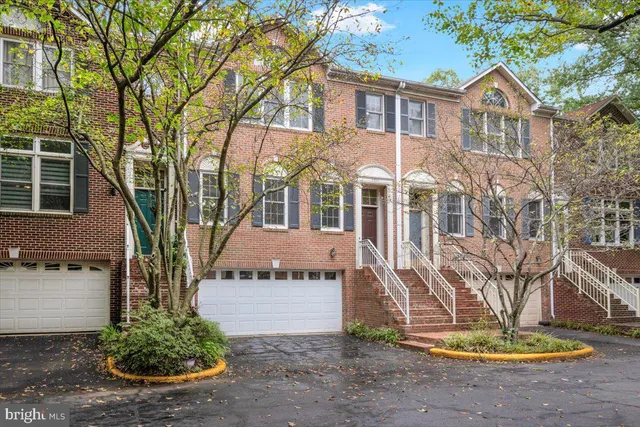 a front view of a house with a yard and potted plants