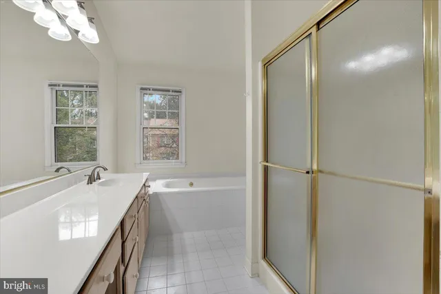 a spacious bathroom with a tub sink and mirror