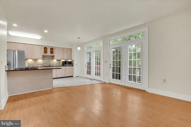 a view of a kitchen with stainless steel appliances wooden floor and a window