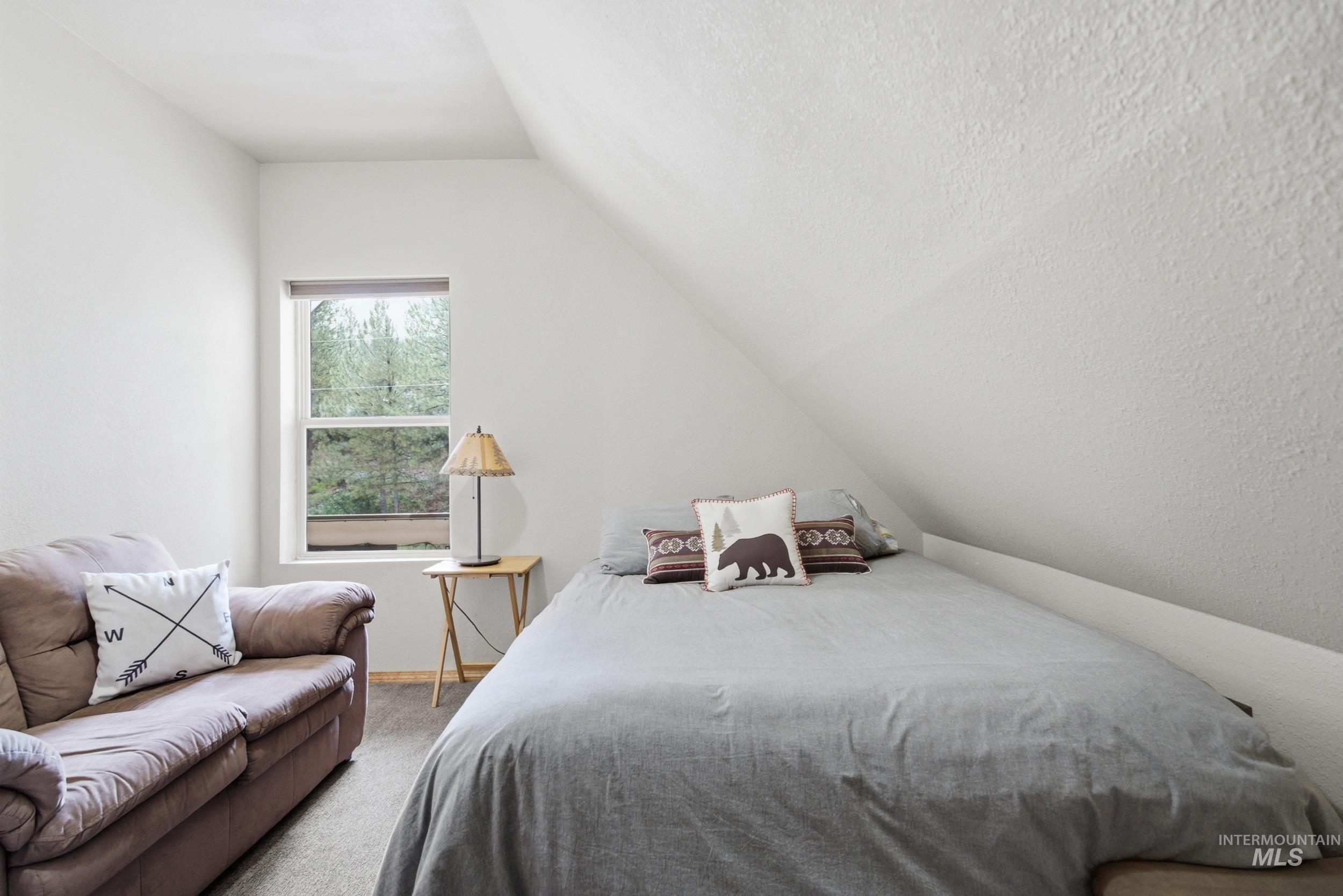 3980 North Pine-Featherville Road Mountain Home, ID 83647 - Photo 25 of 35 Bedroom featuring a sloped ceiling, single window with natural light, and carpeted flooring