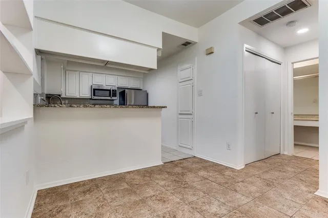a view of a kitchen with cabinets and wooden floor