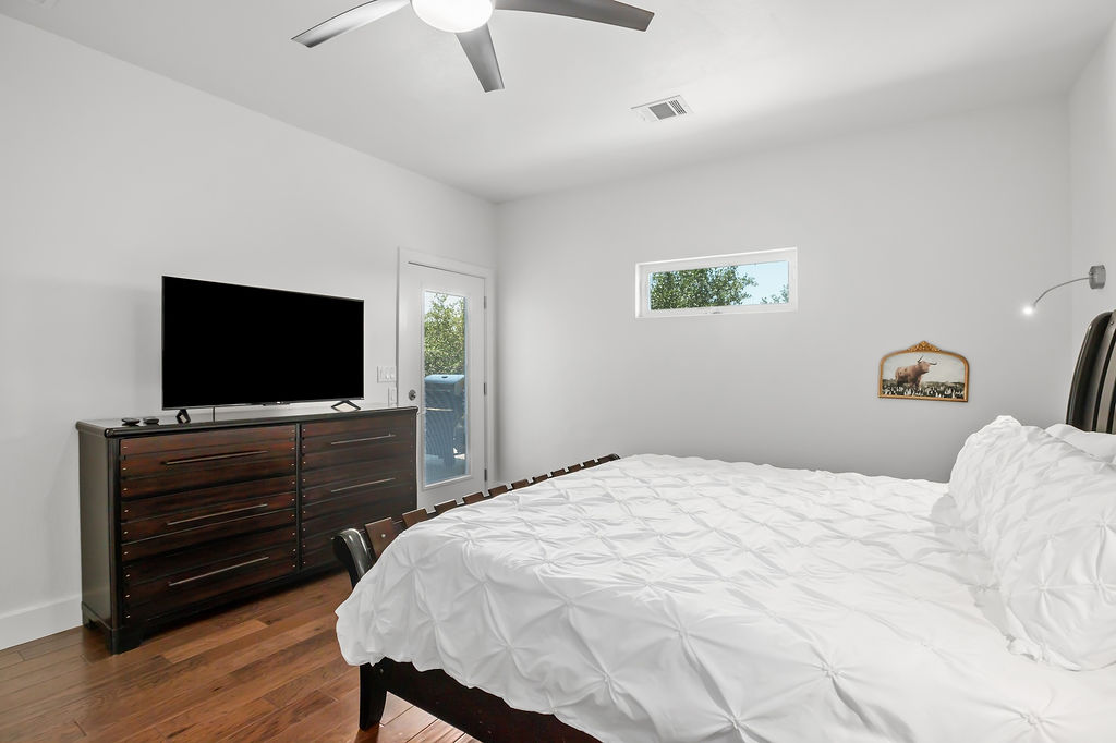 13326 Trautwein Road Austin, TX 78737 - Photo 16 of 40 a bedroom with a bed and a flat screen tv